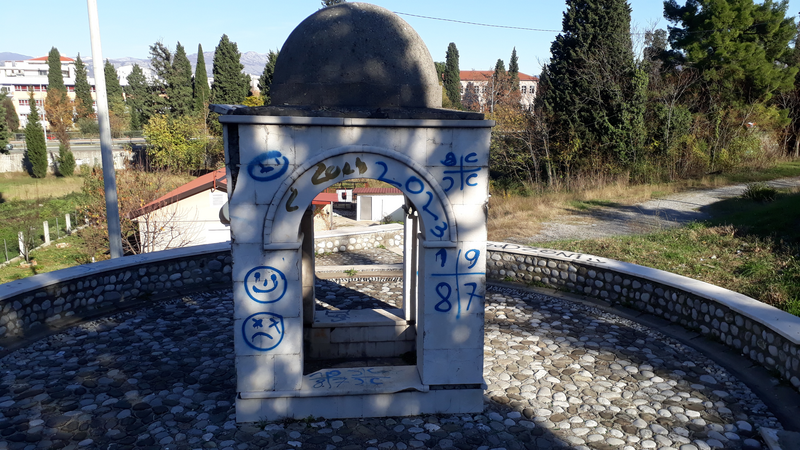 Side of the turbe with grafitti, including crude faces, the date "2023" and two-by-two grids containing "CCCC" (four Cyrillic S's) and "1987"