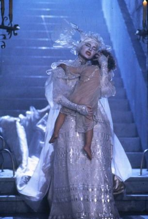 Detail from still of Coppola's /Bram Stoker's Dracula/ showing Lucy, in an absolutely over-the-top dress and veil, descending a blue-lit staircase cradling a child in her arms