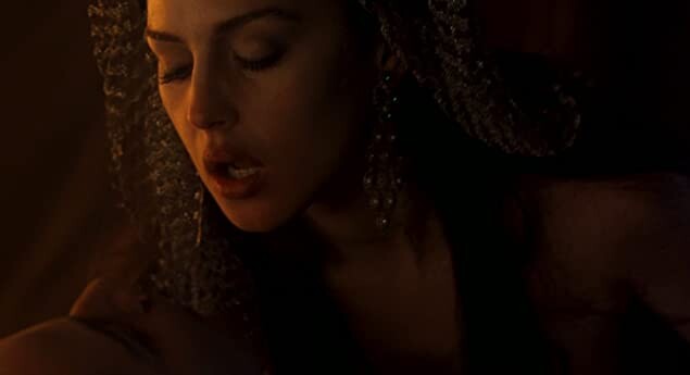 Movie still: Female vampire poised above Harker with her eyes closed and mouth open.