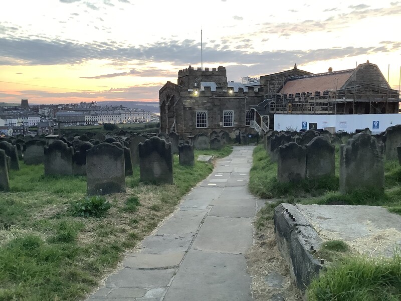 Sunset view of tombstones and walking path in front of St Mary’s Church, Whitby